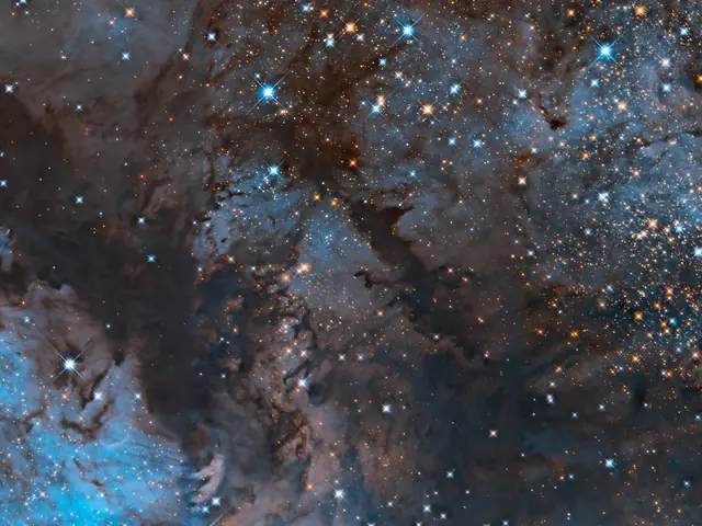 Blue and orange stars glitter across the image, interwoven with dark clouds of brown dust and bright, glowing regions of blue.
