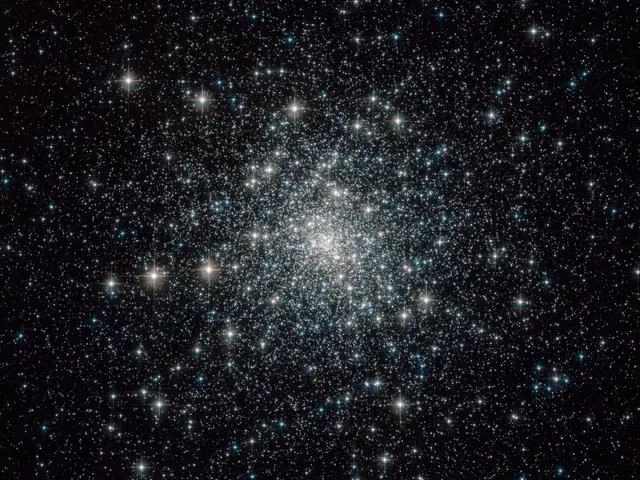 Thousands of mostly white and yellowish stars in a globular cluster.