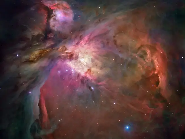 An intense cloud of red, purple, brown and similar color gas that is the Orion Nebula that includes pockets of starbirth.