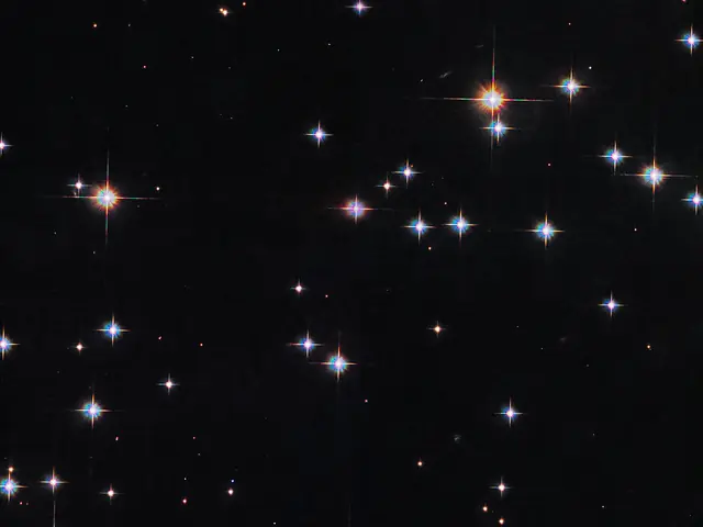 A scattering of white and reddish stars on a black background.