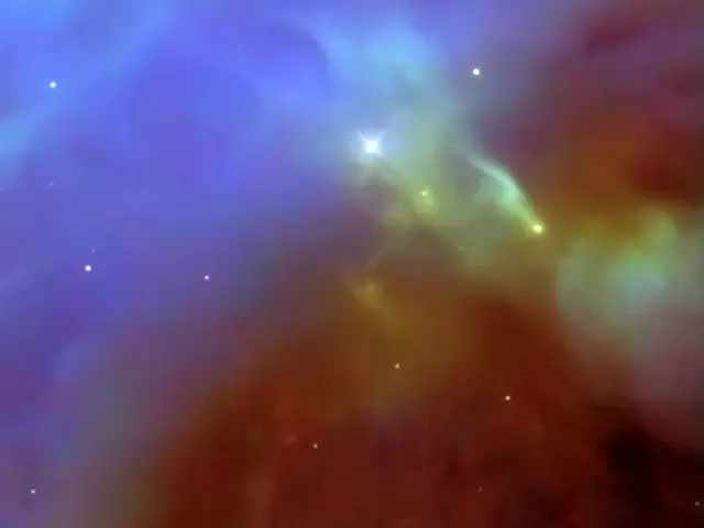 A hazy, cloudy region mostly in blue in the upper left diagonal half of the image, and mostly brown and yellow near the lower right diagonal.