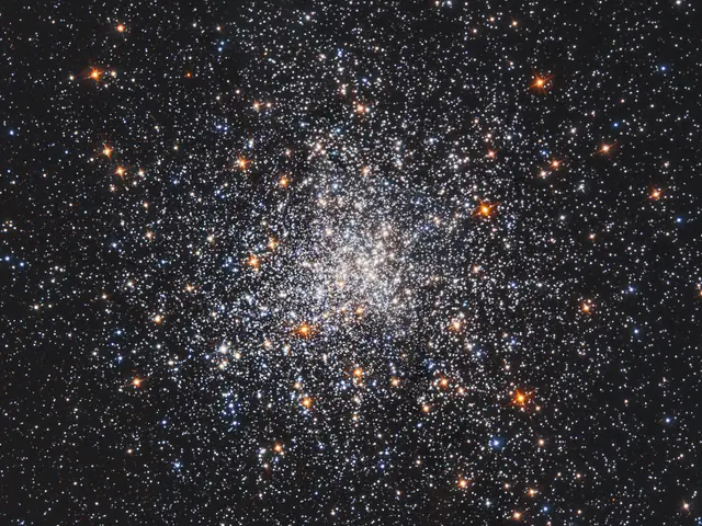 A cluster or white and orange stars, more densely concentrated at the center.