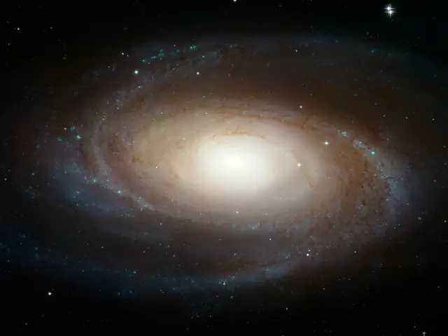 A bright spiral galaxy with a large, yellow core, with small spiral arms surrounding it.