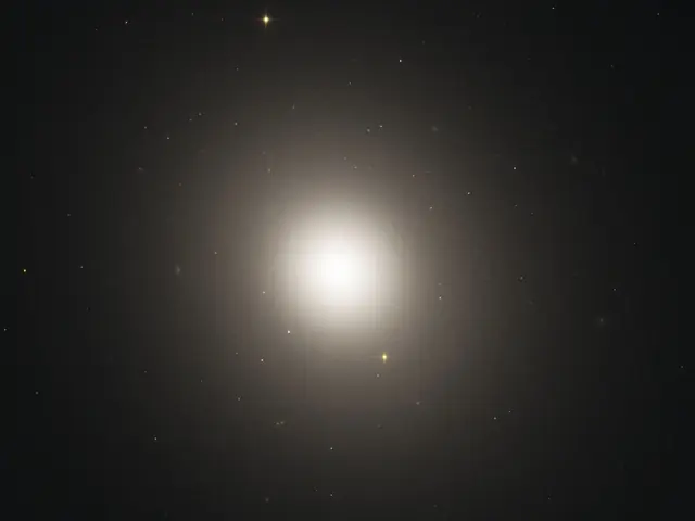 A hazy white-yellow light shines against black space, dotted with faint, distant stars.